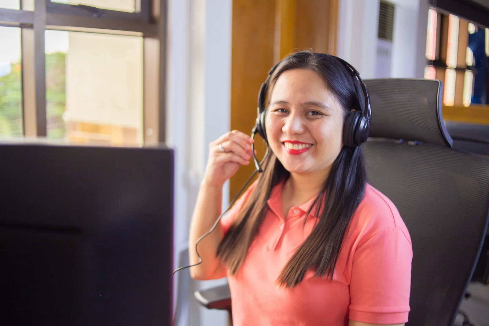 Professional Filipino BPO worker smiling at desk